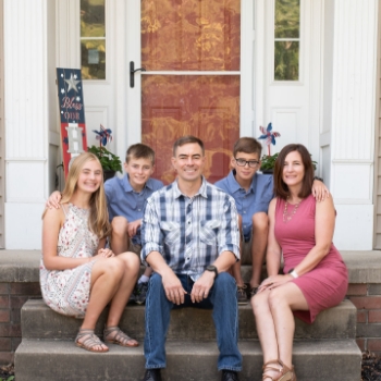 Chris Banweg and his family sitting on the front porch